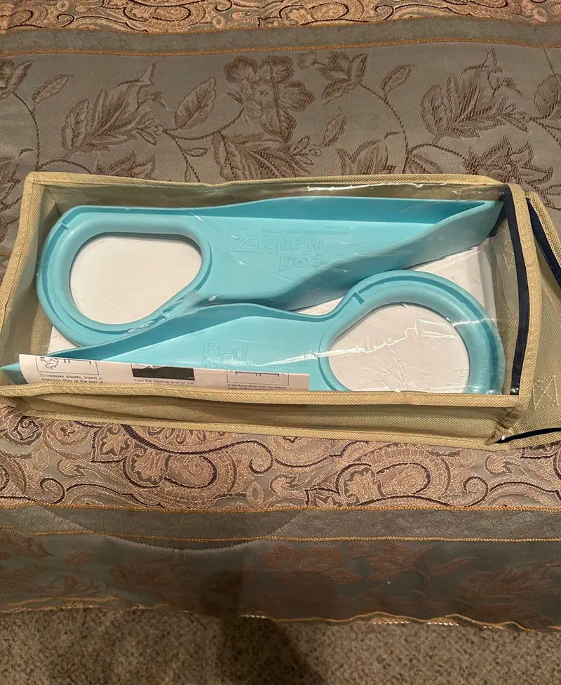 Two light blue mattress lifters in a clear-top storage box on a patterned bedspread