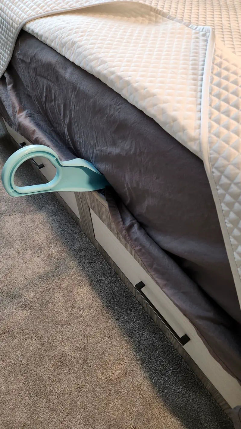 Light blue mattress lifter inserted under a quilted mattress on a grey bed frame with drawers