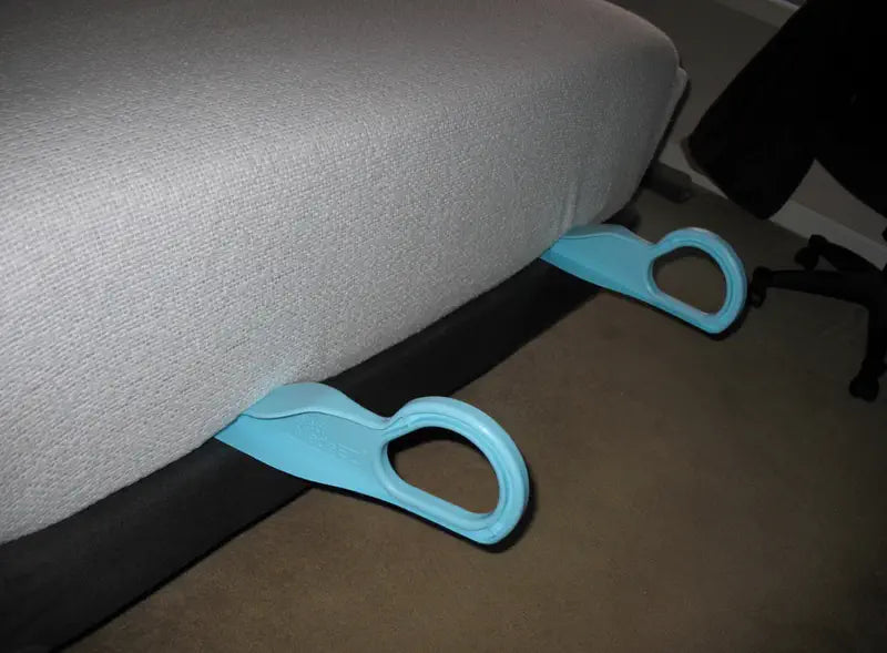 Two light blue mattress lifters holding up the edge of a grey mattress